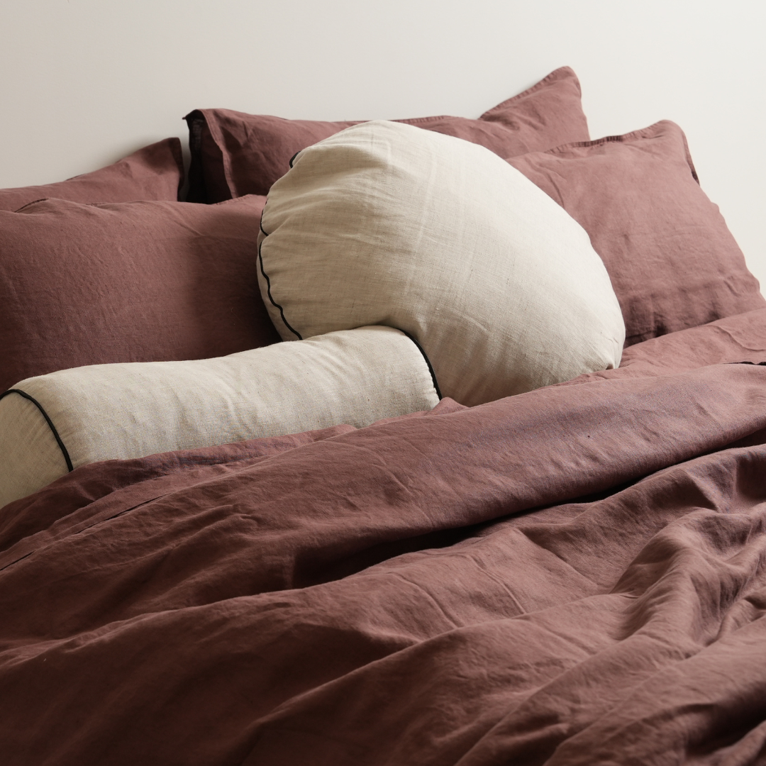 100% french flax linen piped feather filled bolster cushion in natural oat/ black, detail view