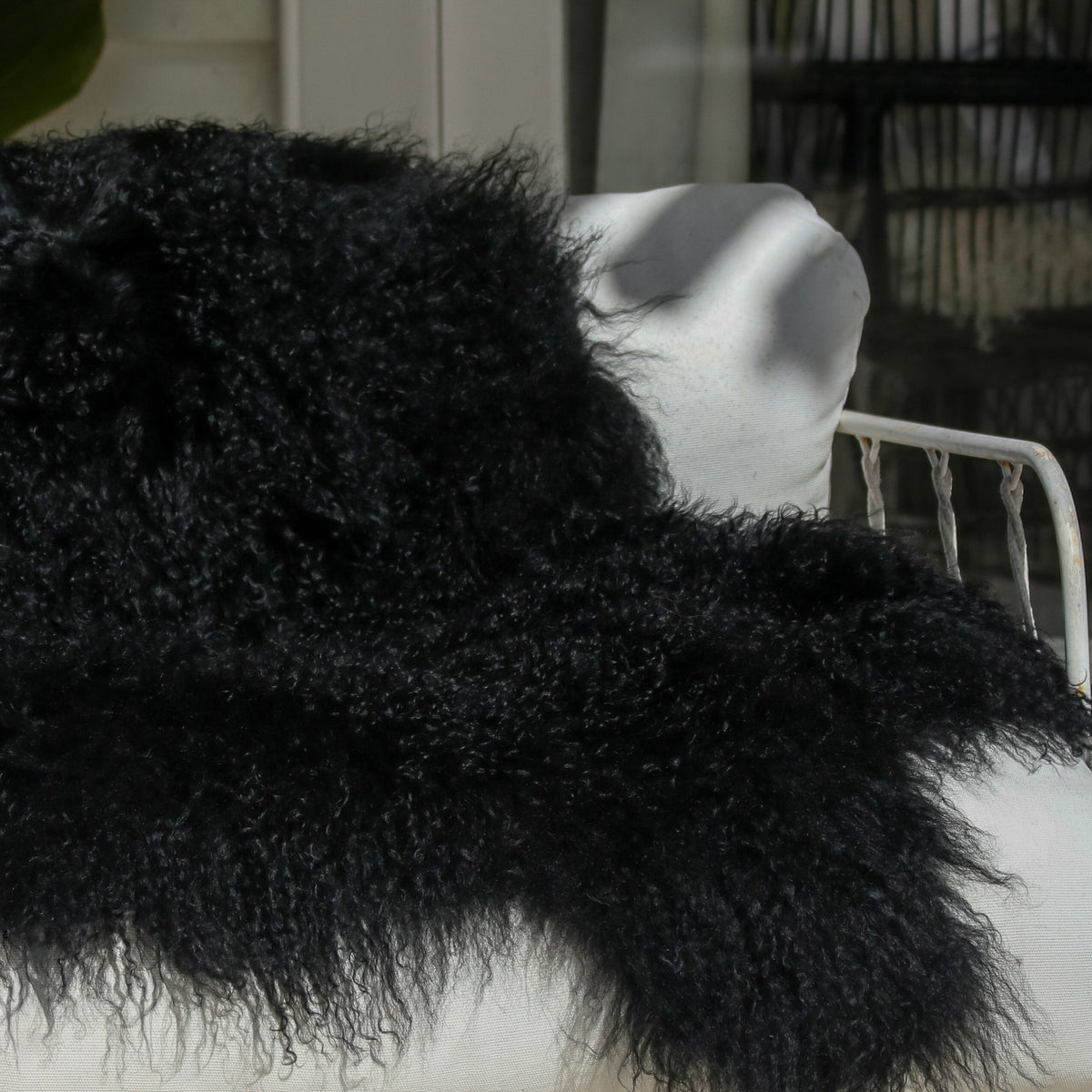 Tibetan lambskin rug in Black, long curly lambswool pile, side view