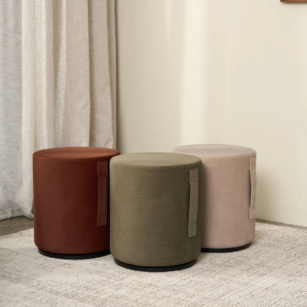 Mee swivel ottoman in Olive, compact form, smooth swivel base, side view