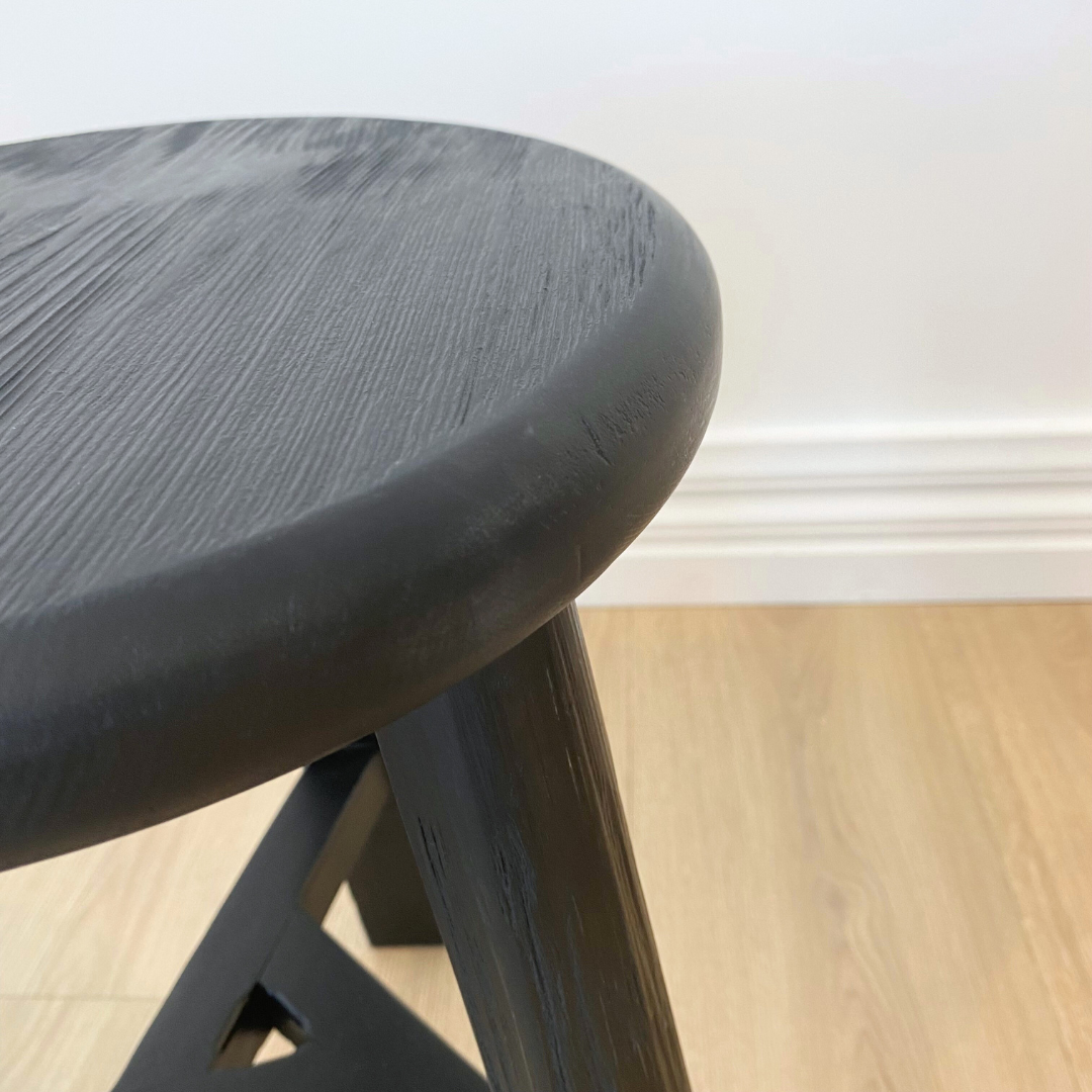 Reclaimed wooden tripod stool in black, close-up